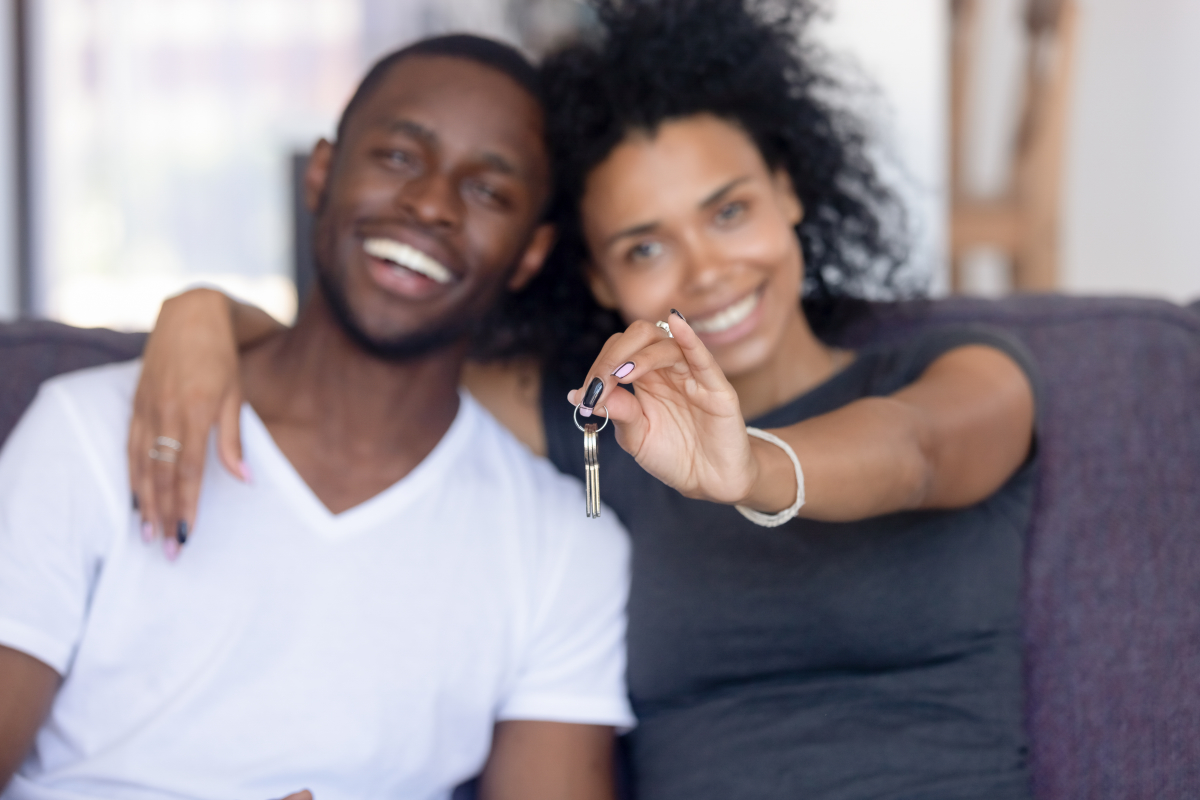 ”Acheter une maison à deux” ”un couple afro-américain montre les clefs d'une maison qu'ils viennent d'acheter”