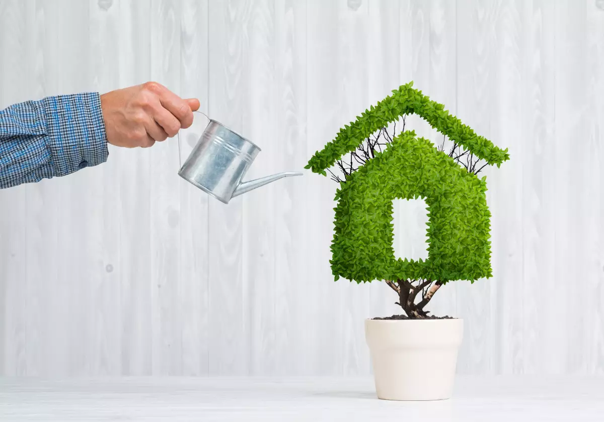 Les programmes neufs plus écologiques à Montpellier conseil achat immobilier neuf - Concept de l'immobilier neuf écologique avec un arrosoir et une maison verte