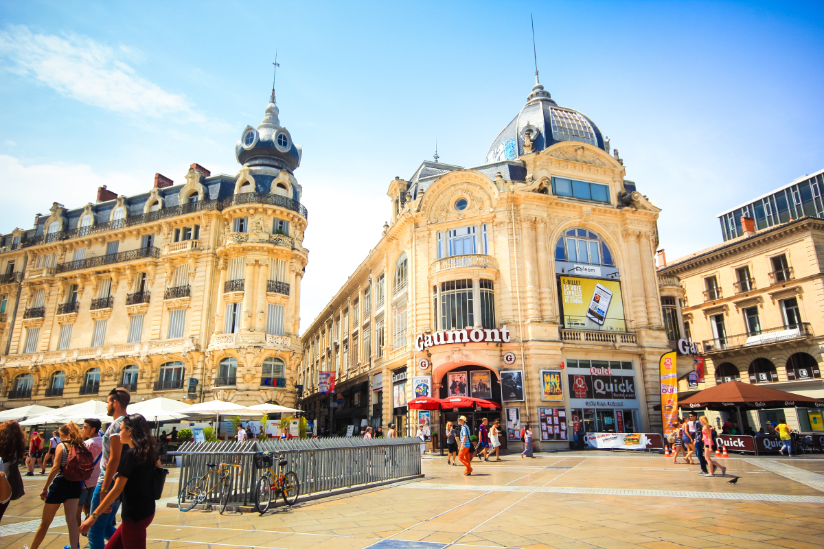  Quartiers où investir en loi Pinel à Montpellier – Opéra national de Montpellier avec des passants dans la rue en plein jour