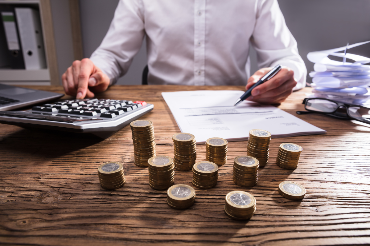 Il faut veiller à bien prendre en compte tous les coûts actuels et à venir lors d’un investissement locatif Investissement locatif Montpellier –Homme calculant ses recettes et dépenses à l’aide d’une calculatrice