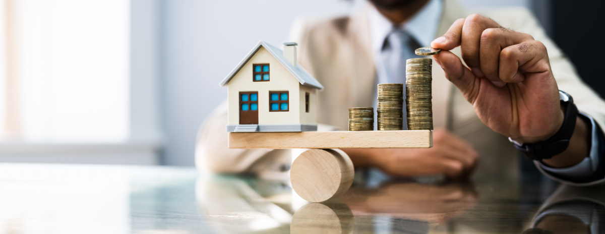 Acheter un bien immobilier en VEFA présente plusieurs avantages financiers et fiscaux VEFA Montpellier – Maisonnette et tas de pièces sur une balance en bois