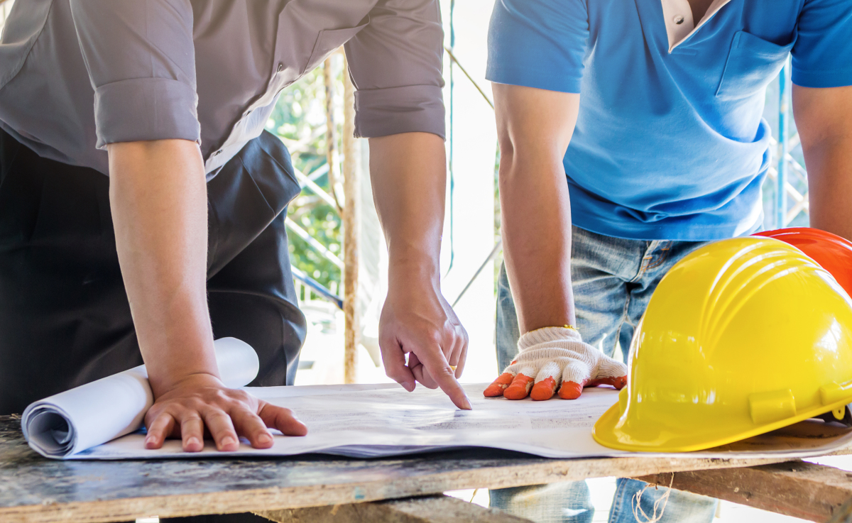 Quels sont les travaux éligibles avec la loi Denormandie ? Loi Denormandie – vue sur des professionnels s’apprêtant à réaliser des travaux à partir d’un plan