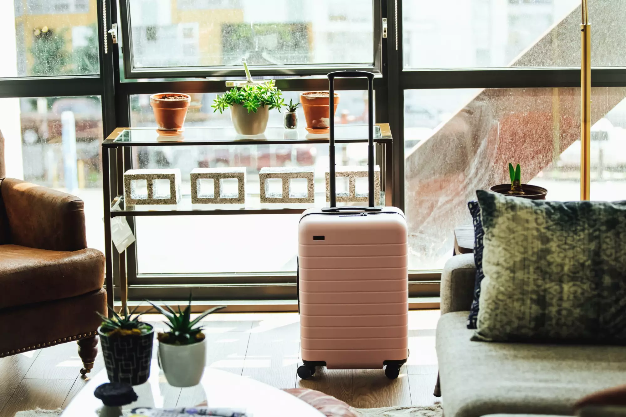 Valise devant une baie vitrée vue sur la ville