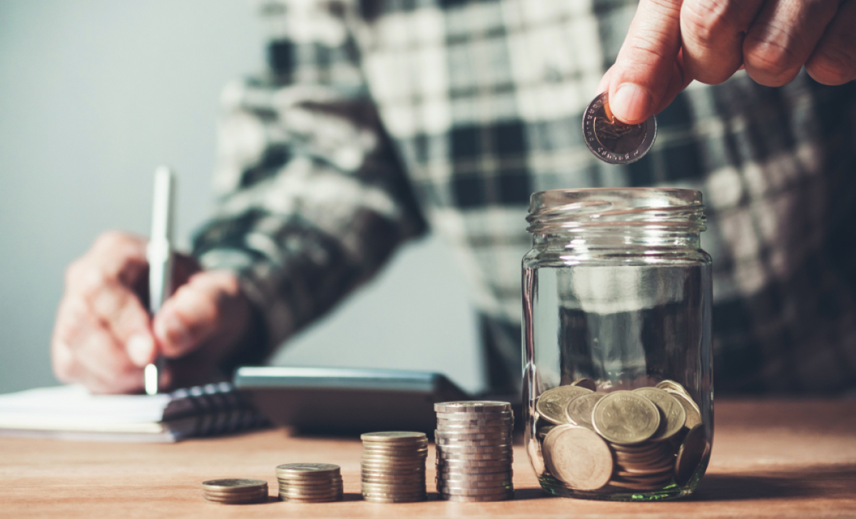 L’investissement immobilier petit budget à Montpellier Investissement locatif Montpellier avec un petit budget – Un homme remplit un bocal avec des pièces de monnaie