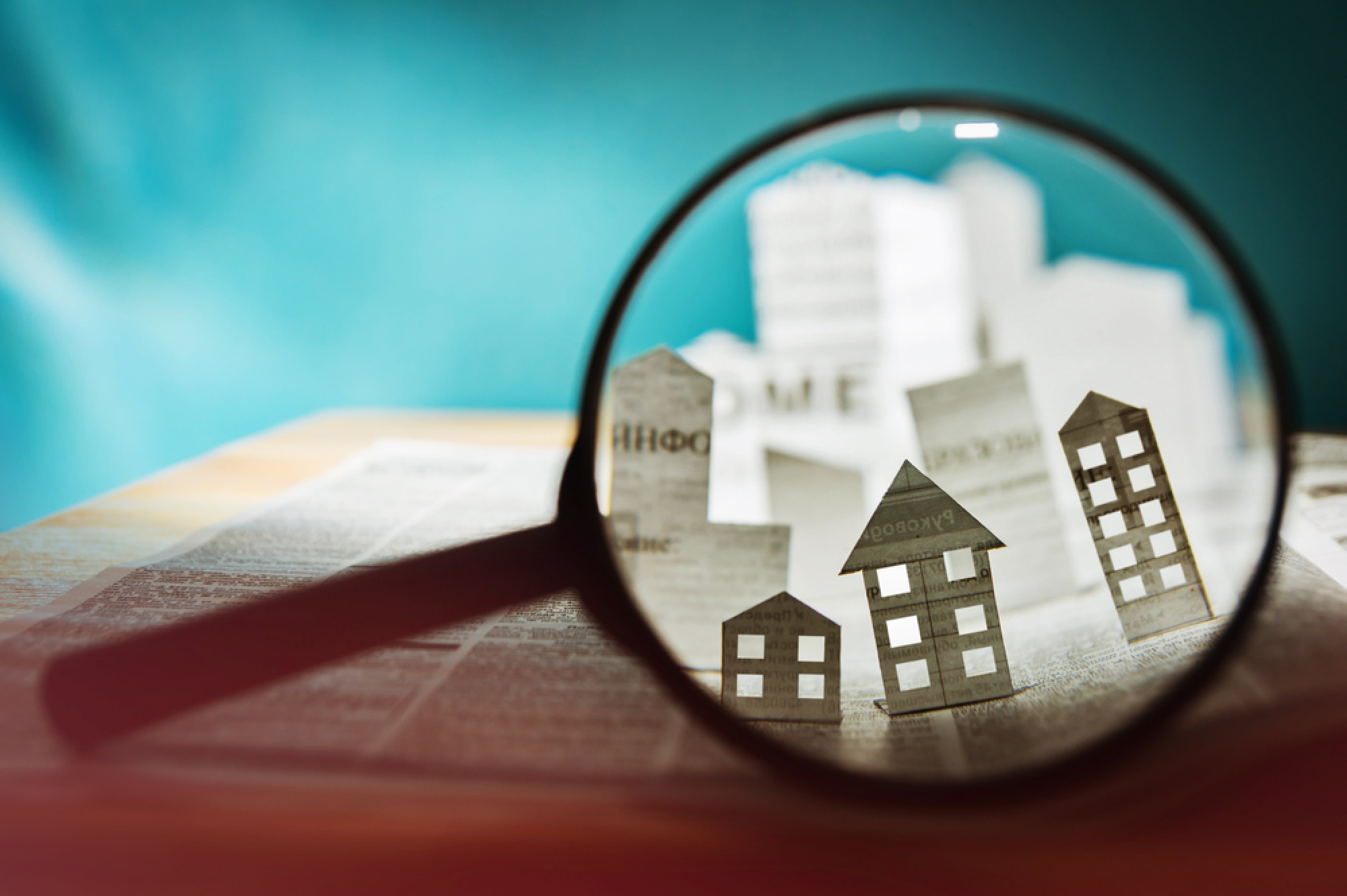 Une loupe montrant des maisons de papier