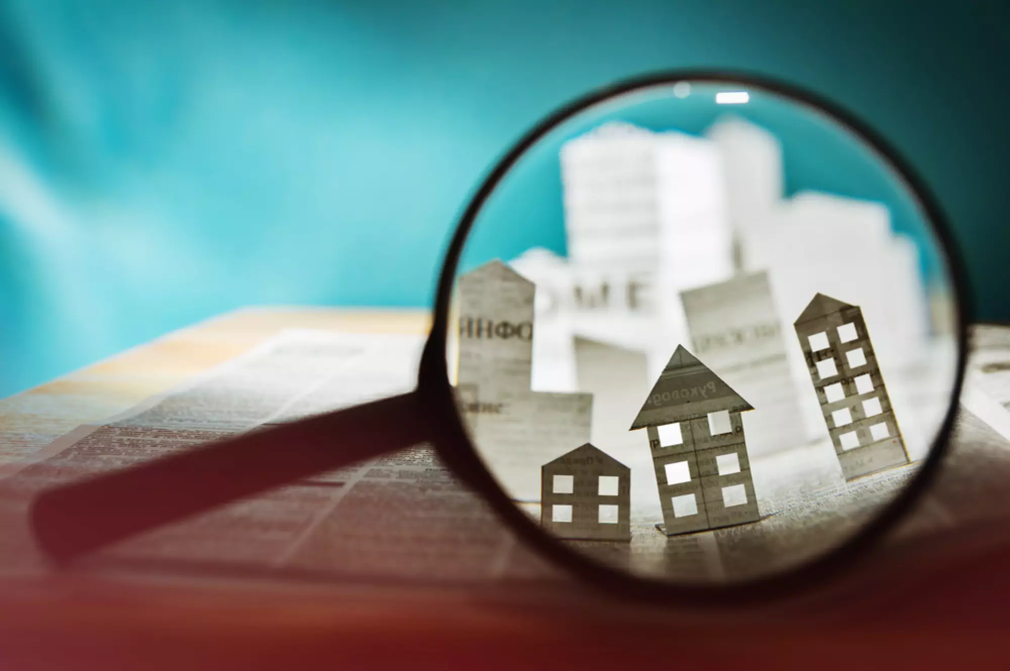 Une loupe montrant des maisons de papier