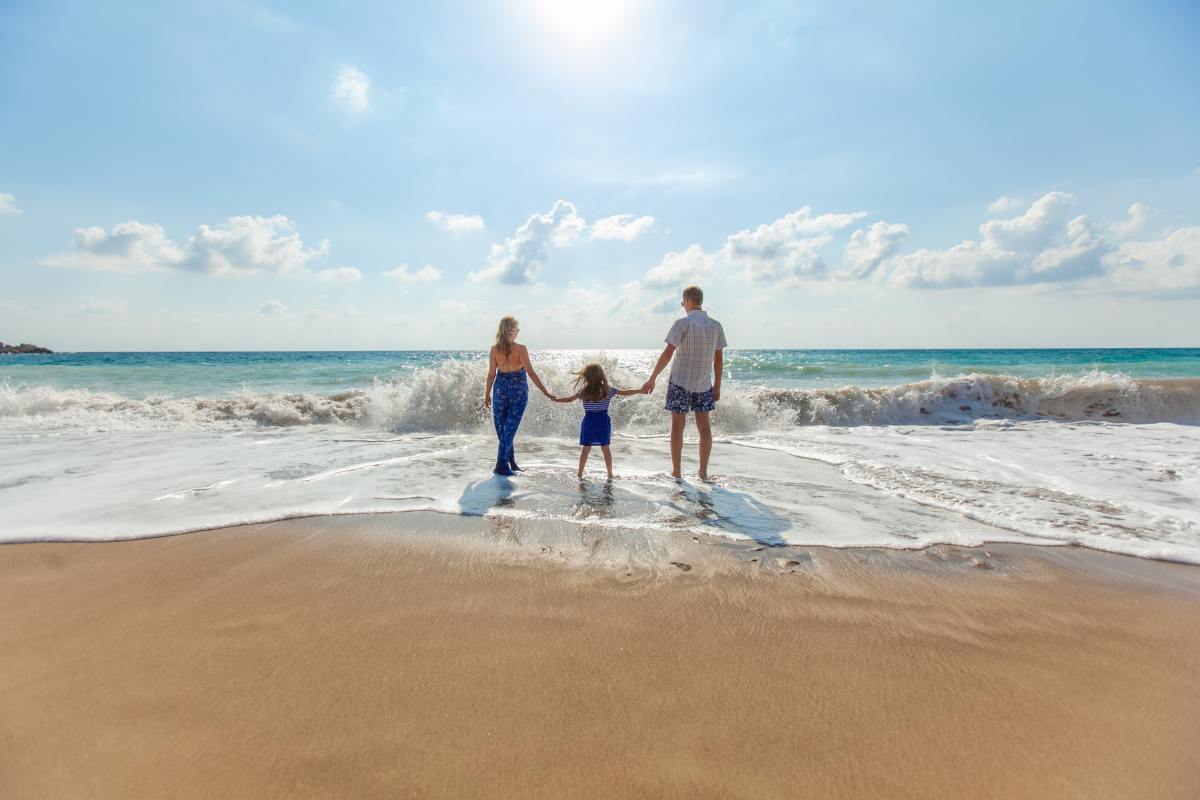 Vivre à Montpellier en famille – Une famille à la plage les pieds dans l’eau