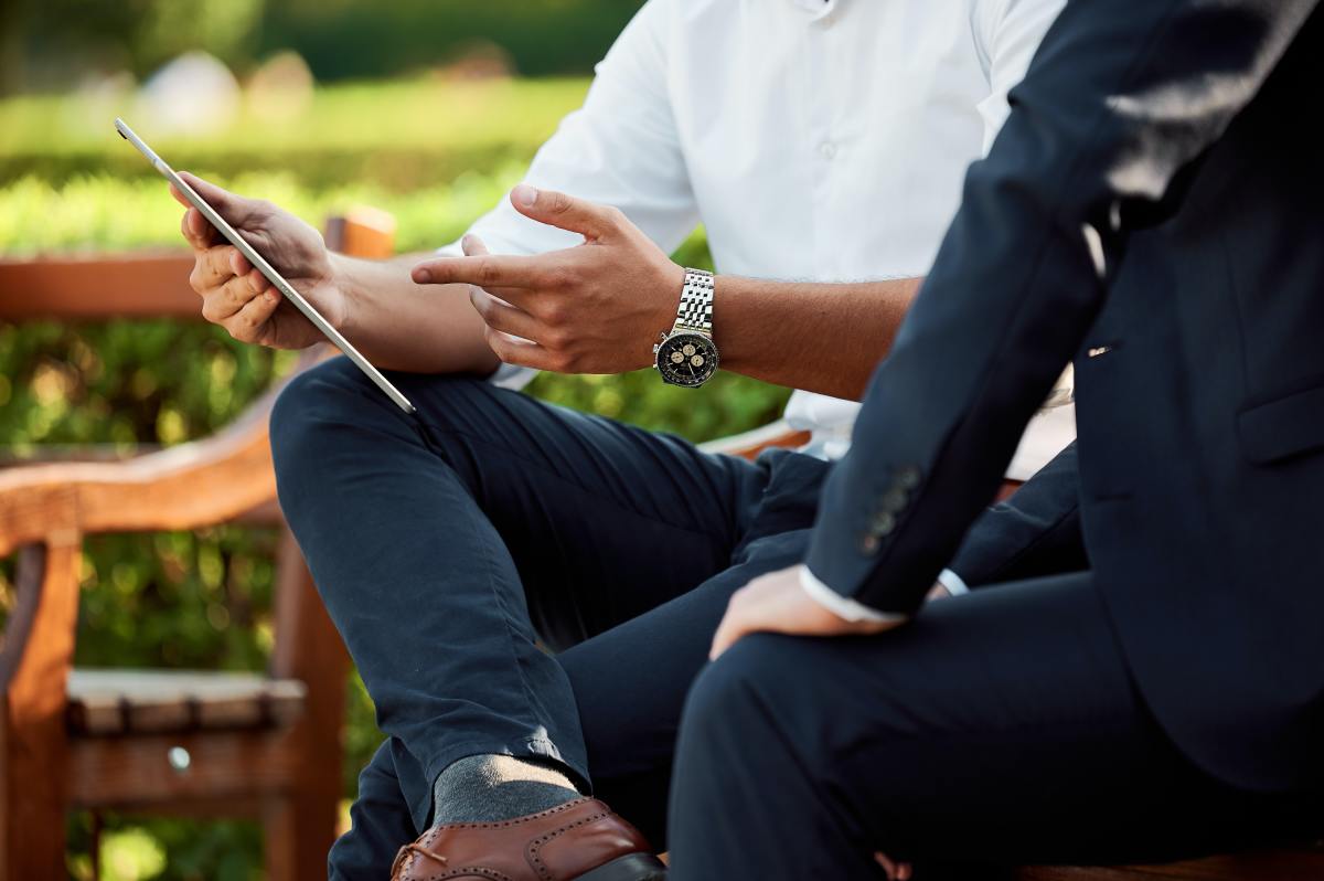 À quoi faire attention quand on choisit son assurance emprunteur ? loi assurance emprunteur – Un homme assis dans un parc comparant les offres d’assurance
