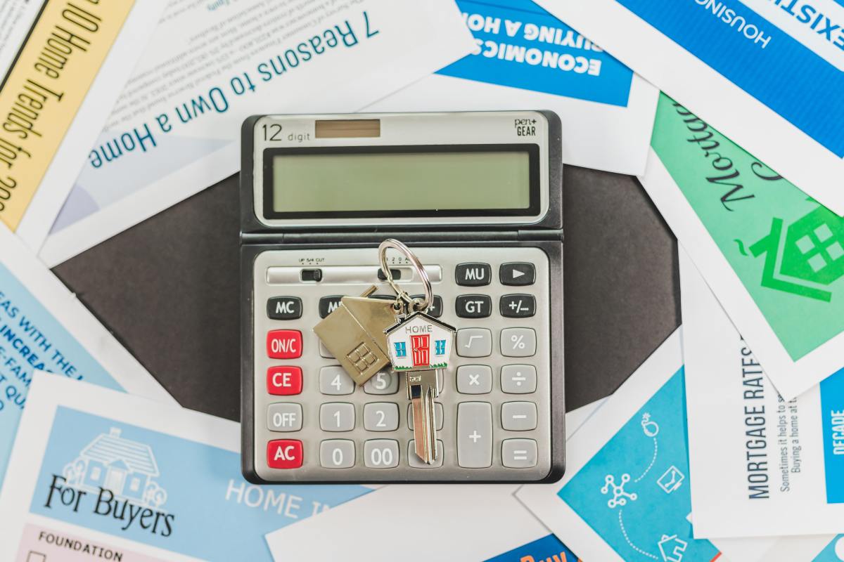 Est-ce rentable de revendre un appartement neuf ? revendre un appartement neuf – Une calculatrice avec une clé au milieu de feuilles
