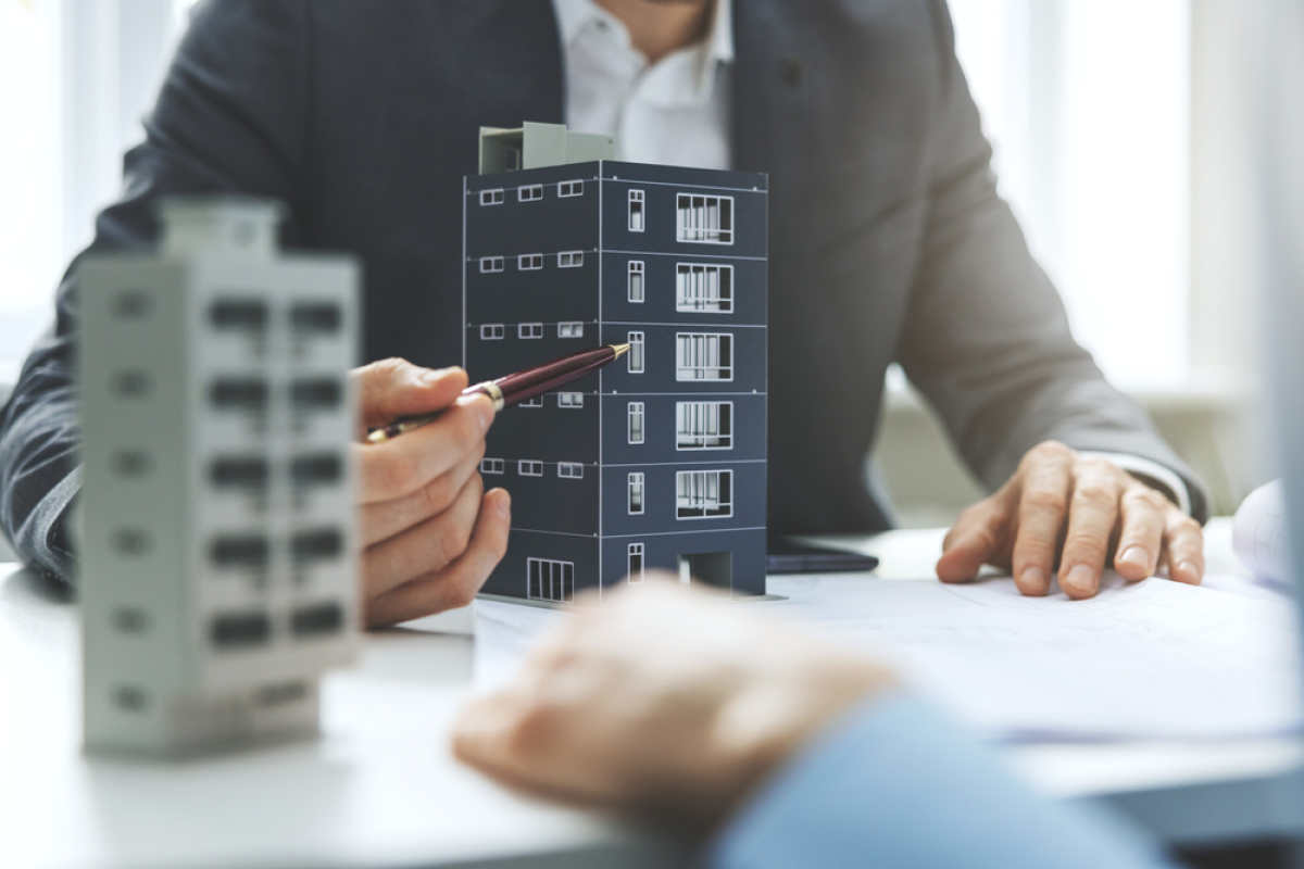 proposition de loi simplification urbanisme – un promoteur immobilier discutant d’un programme immobilier neuf avec une maquette à Montpellier