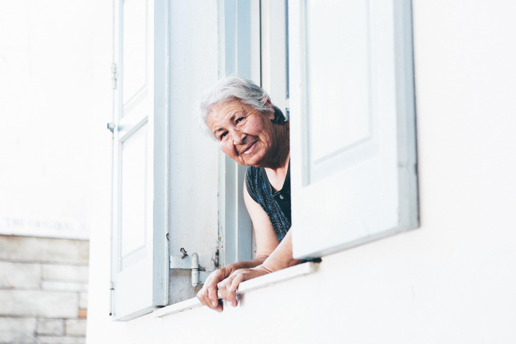 Une dame regarde par sa fenêtre