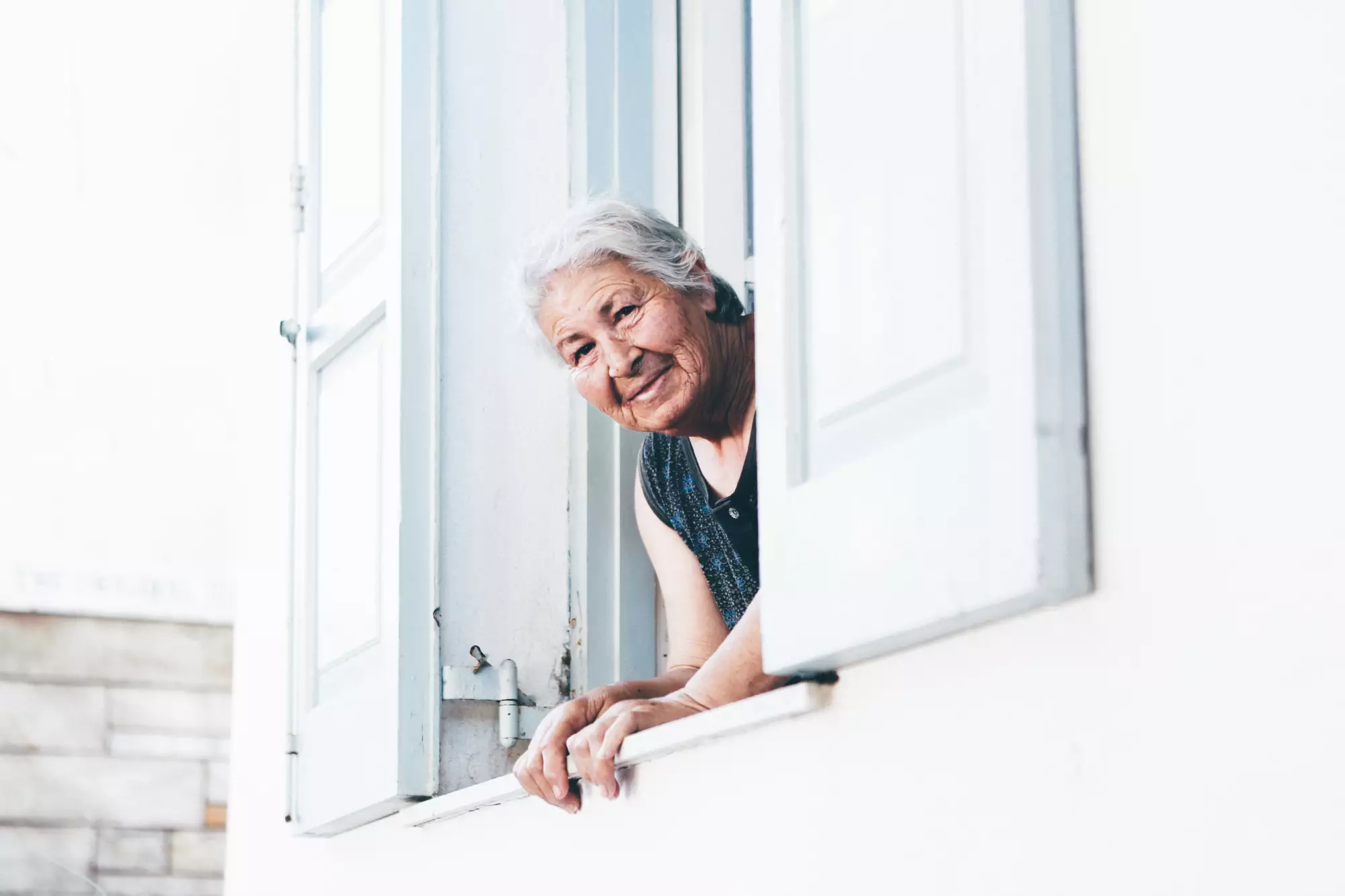 Une dame regarde par sa fenêtre