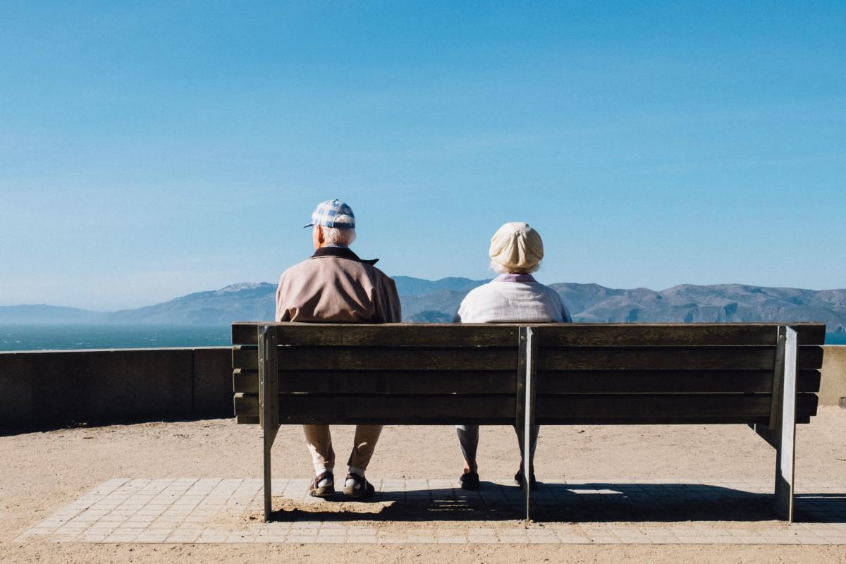 Investir résidence sénior Montpellier – Un couple assis sur un banc face à la mer