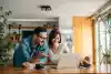 Un couple consulte les offres immobilières sur un ordinateur portable