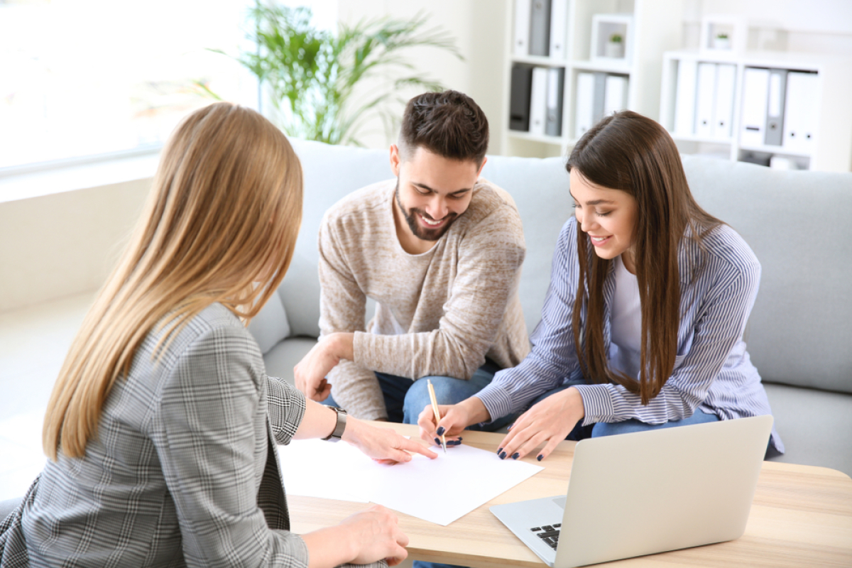 Un jeune couple qui signe l'achat de leur appartement neuf 