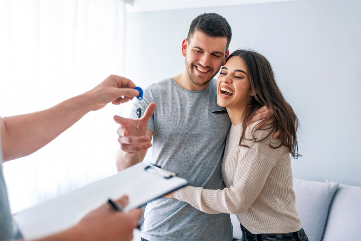 Quels sont les critères pour avoir accès à un prêt aidé en 2023 ? Un couple qui reçoit les clés de son logement