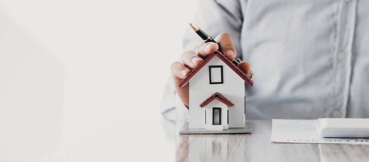 lmnp non géré – un homme pose la main sur une maquette de maison