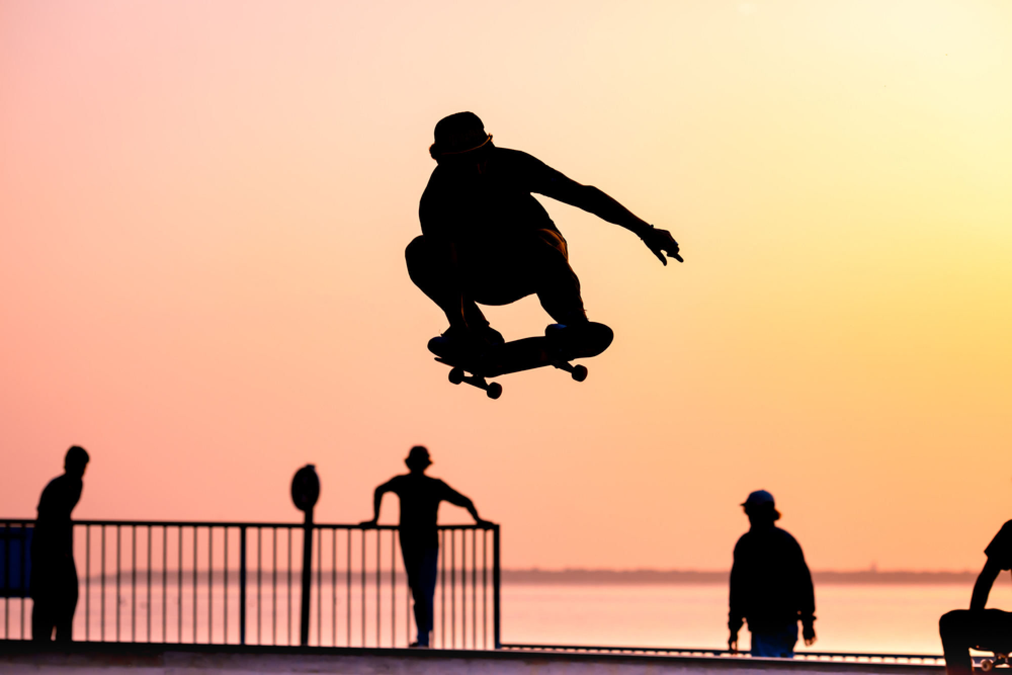 Un skateur réalise une figure sur fond de coucher de soleil