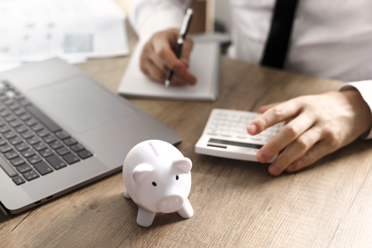 Il est important de considérer tous les détails de sa location Pinel loi pinel location famille – un homme utilise une calculatrice sur un bureau avec une tirelire cochon au premier plan