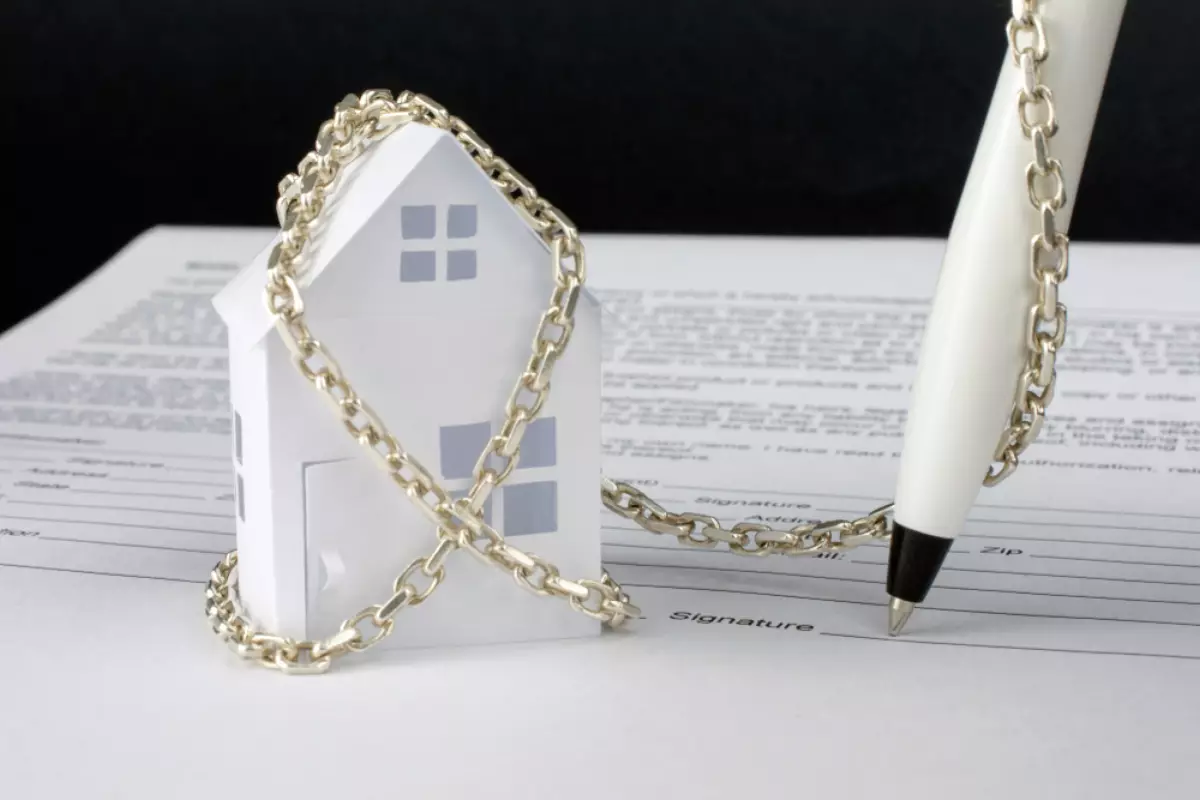 proposition de loi indivision successorale – un stylo enchaîné à une maison sur un contrat