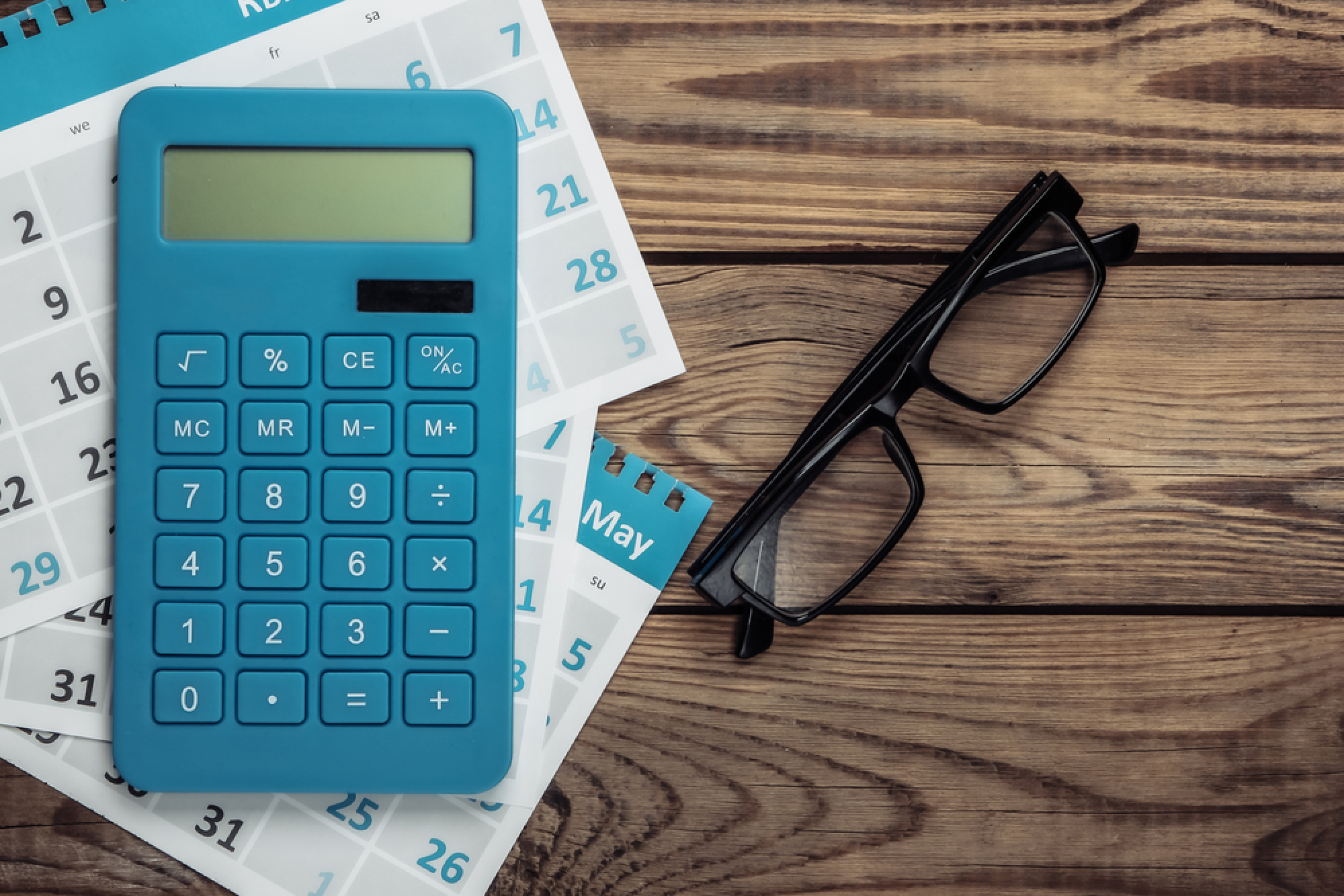 calculatrice et lunettes posées sur une table