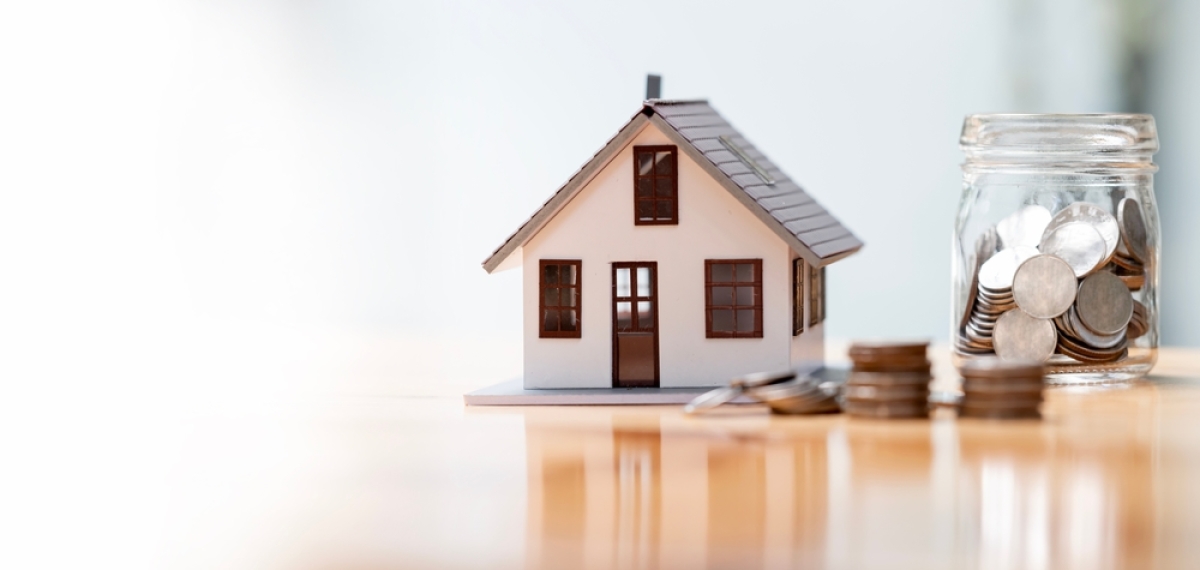 Le PTZ est essentiel pour l’accession à la propriété en France plf 2025 mesures votées par le Sénat – Une maquette de maison posée à côté d'un bocal rempli de pièces de monnaie