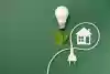 un cordon électrique entoure une maison à côté de feuilles et d’une ampoule