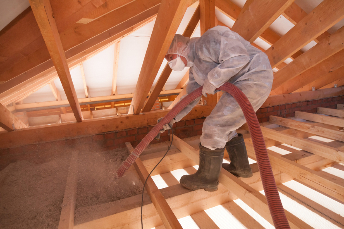 isolation logement neuf – un homme vaporise de l’isolant écologique sous les combles