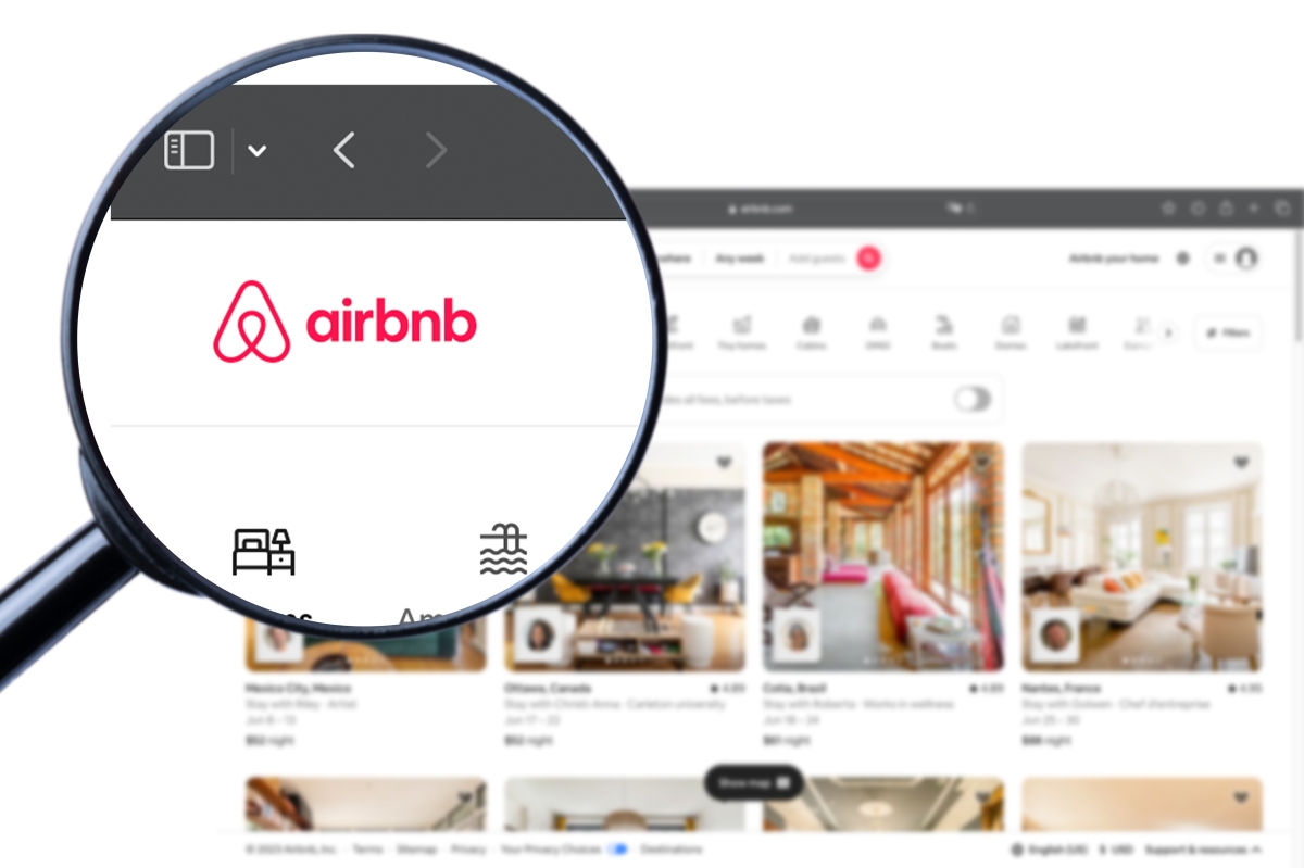 écran d’ordinateur ouvert sur une page airbnb avec une loupe grossissant le logo