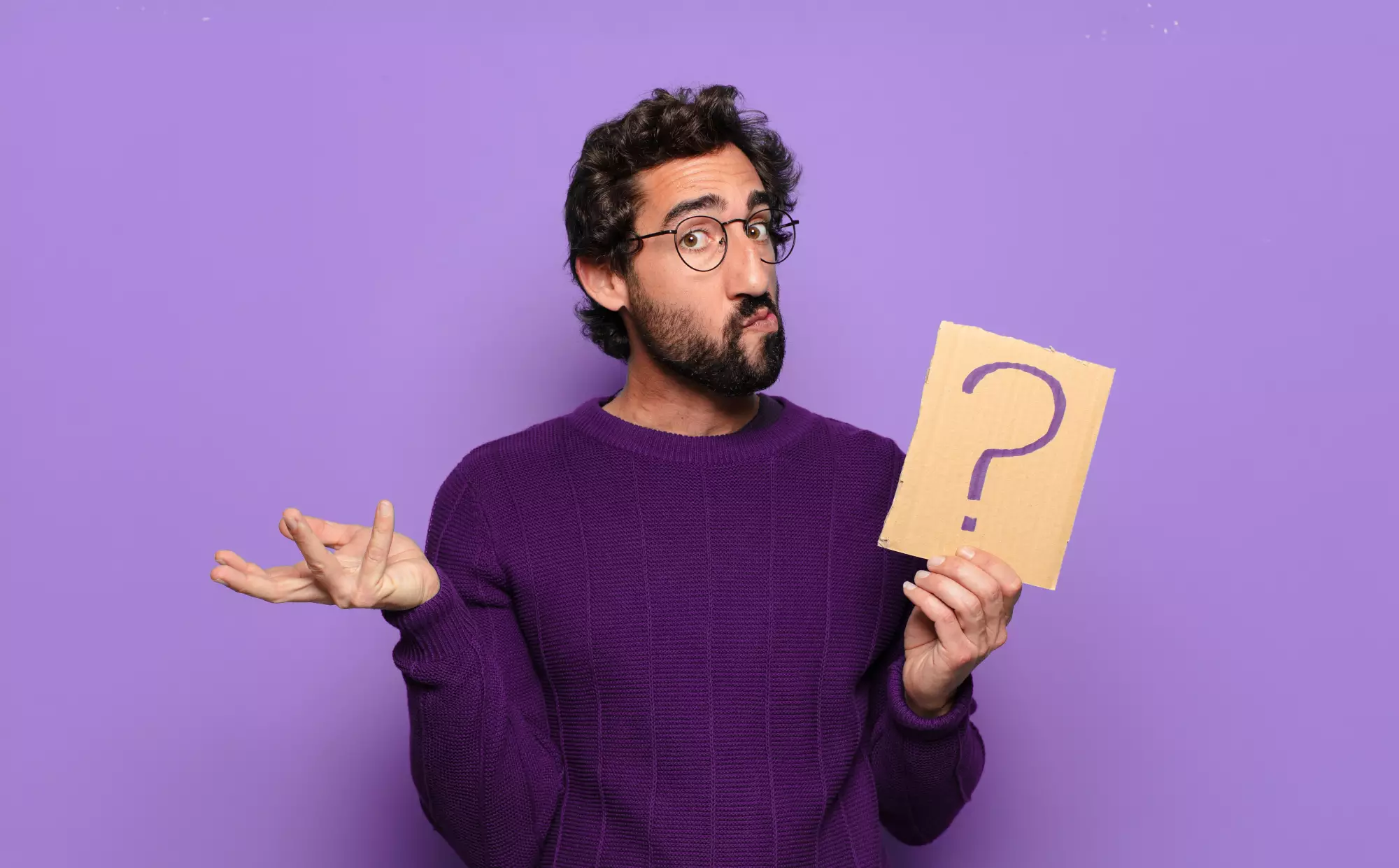 homme avec pull violet sur fond violet tenant une pancarte avec un point d'interrogation