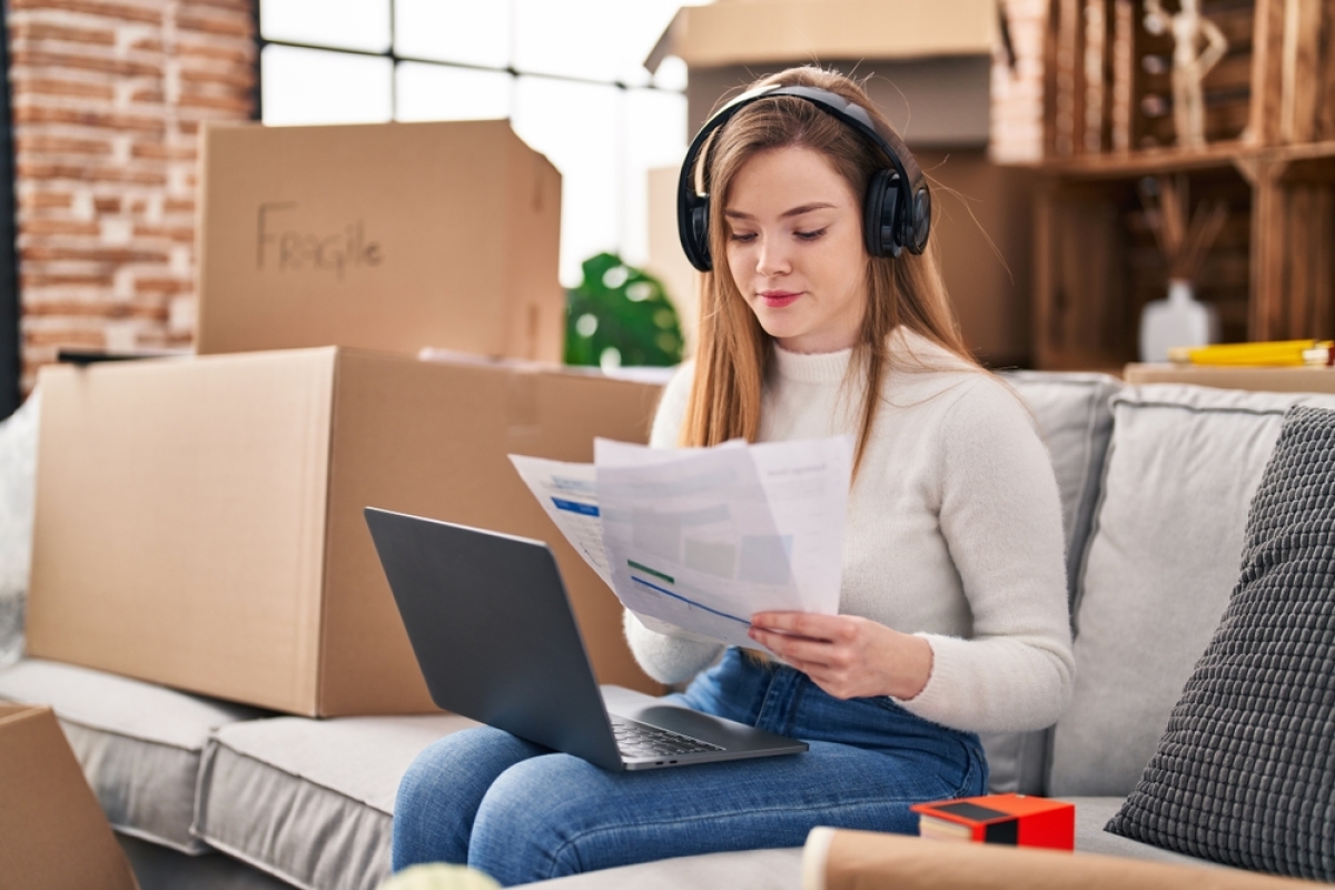 loi pinel location famille – une étudiante révise sur son canapé avec des cartons autour