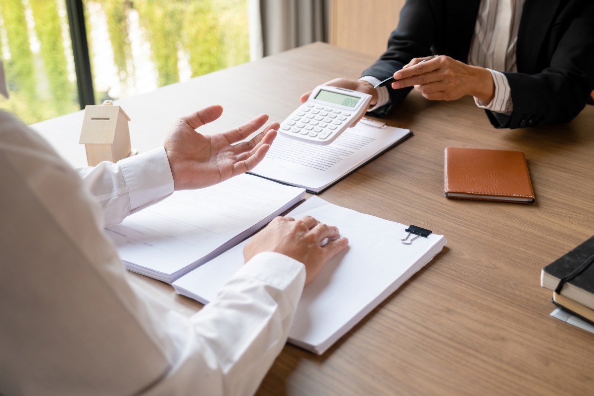 Le bailleur a des droits et des obligations immobilier neuf à Toulouse – des mains montrant des résultats de calcul sur une calculatrice à une personne dont on ne voit que les mains