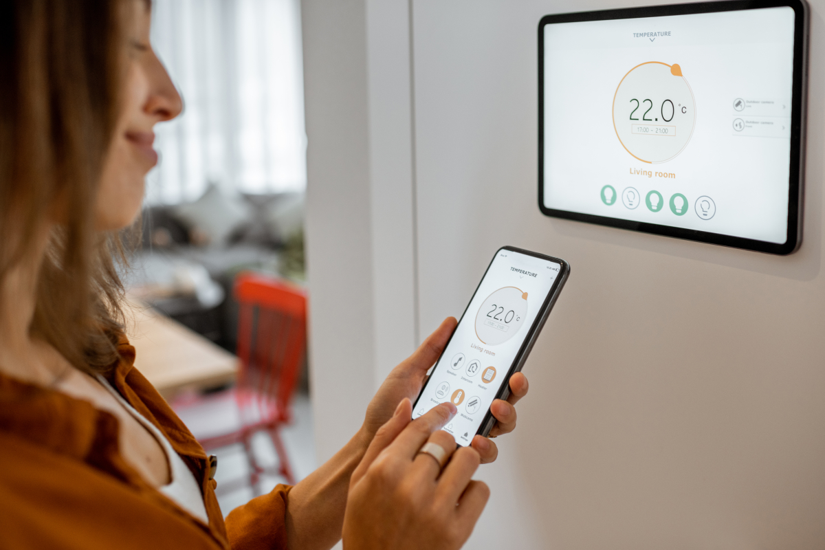 Un système de chauffage connecté permet de réguler sa consommation énergétique renovation energétique 2024 – une femme programme son chauffage intelligent ave son smartphone