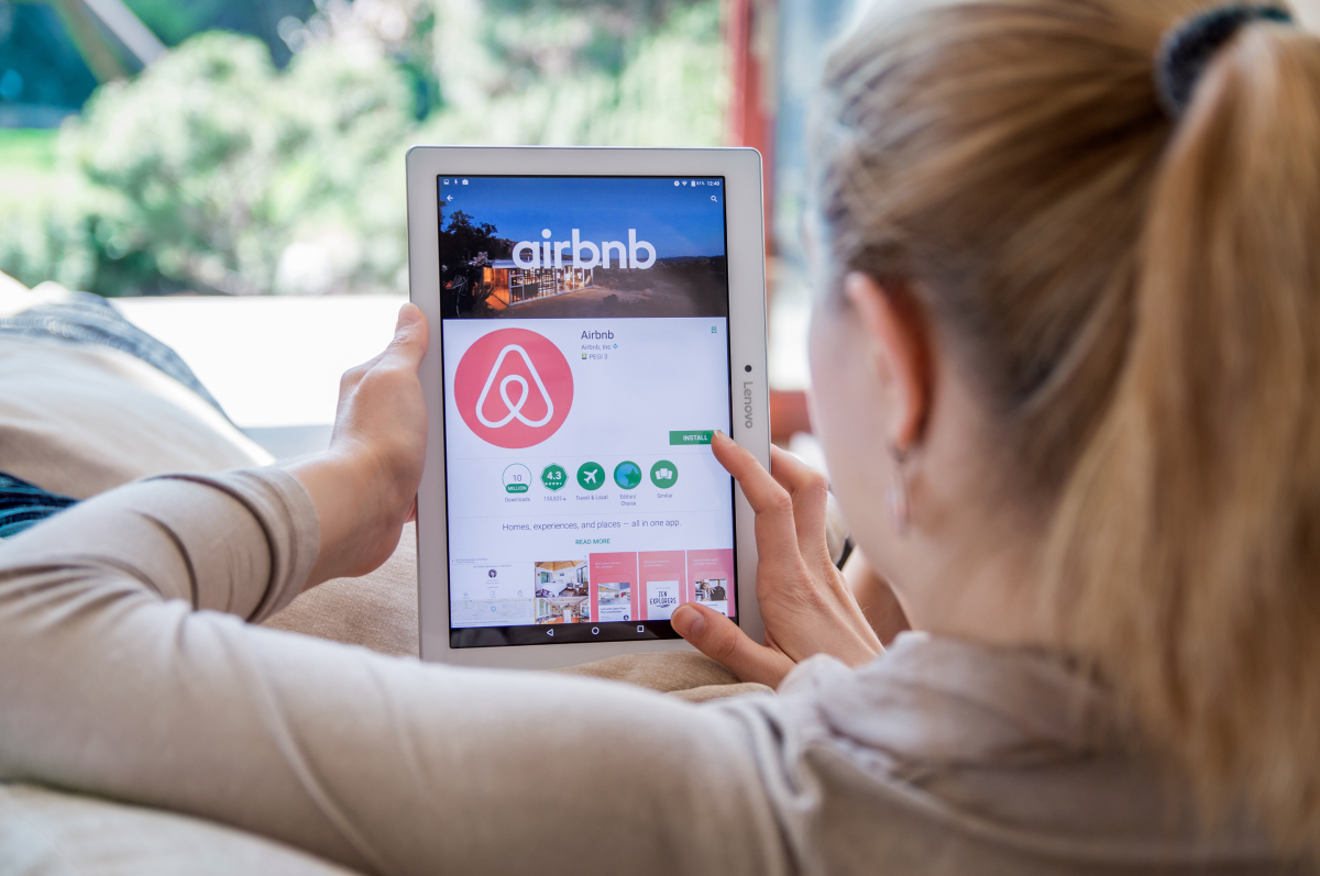 Certains propriétaires préféreront se tourner vers les locations touristiques permis de louer montpellier – une femme sur sa tablette numérique