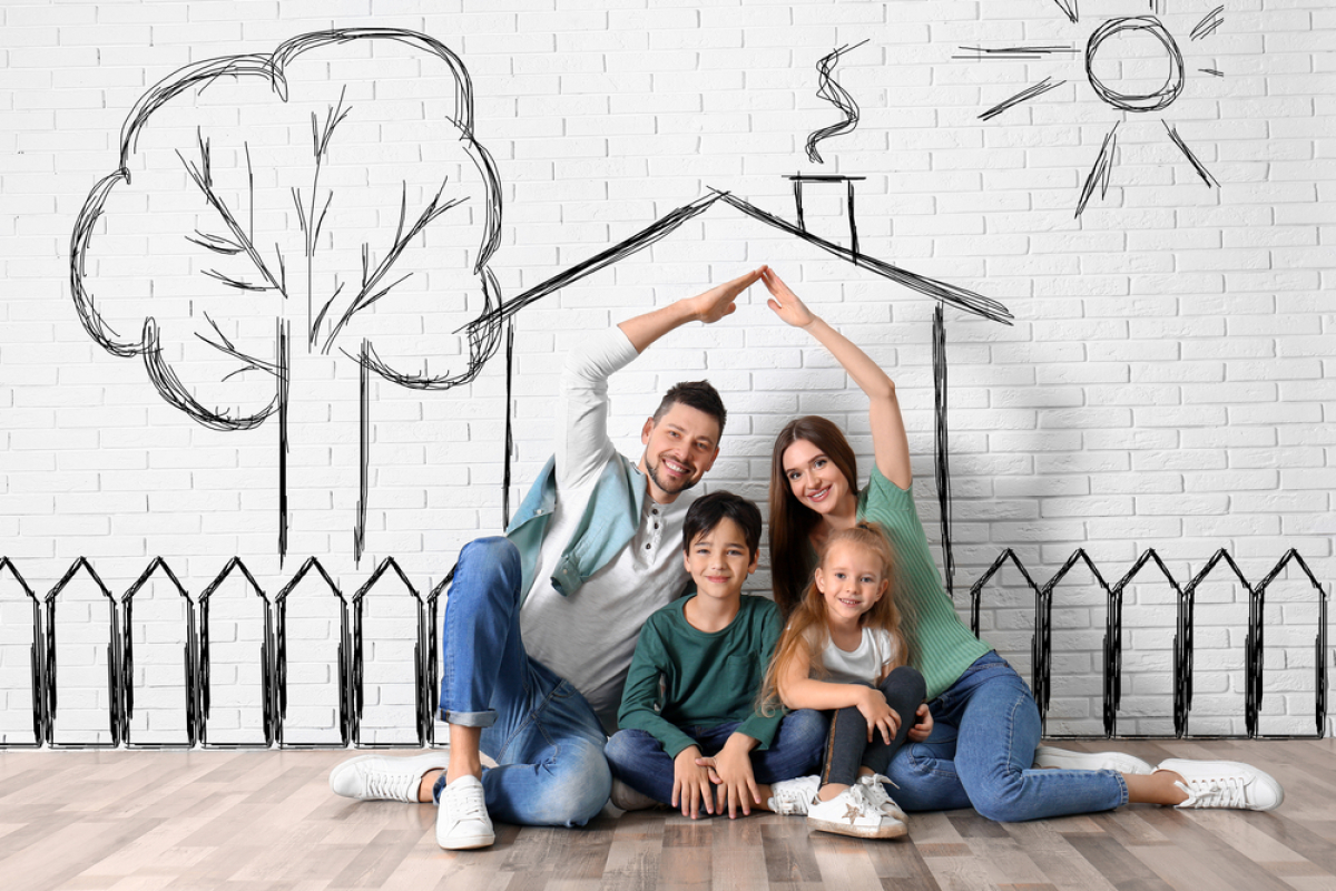 TVA réduite à 5,5 – Une famille assise par terre une maison dessinée sur le mur derrière