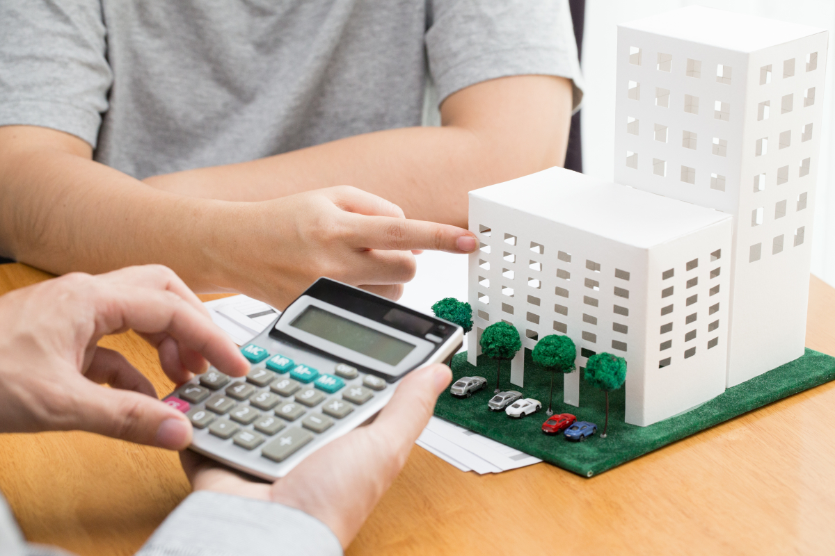 interets intercalaires achat vefa – une maquette de programme neuf et une personne avec une calculatrice