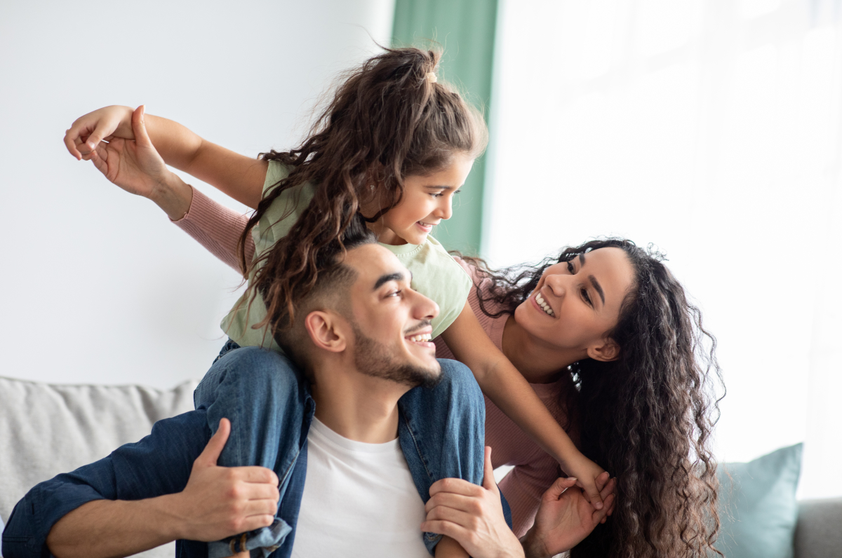 un couple avec sa fille jouant dans un salon