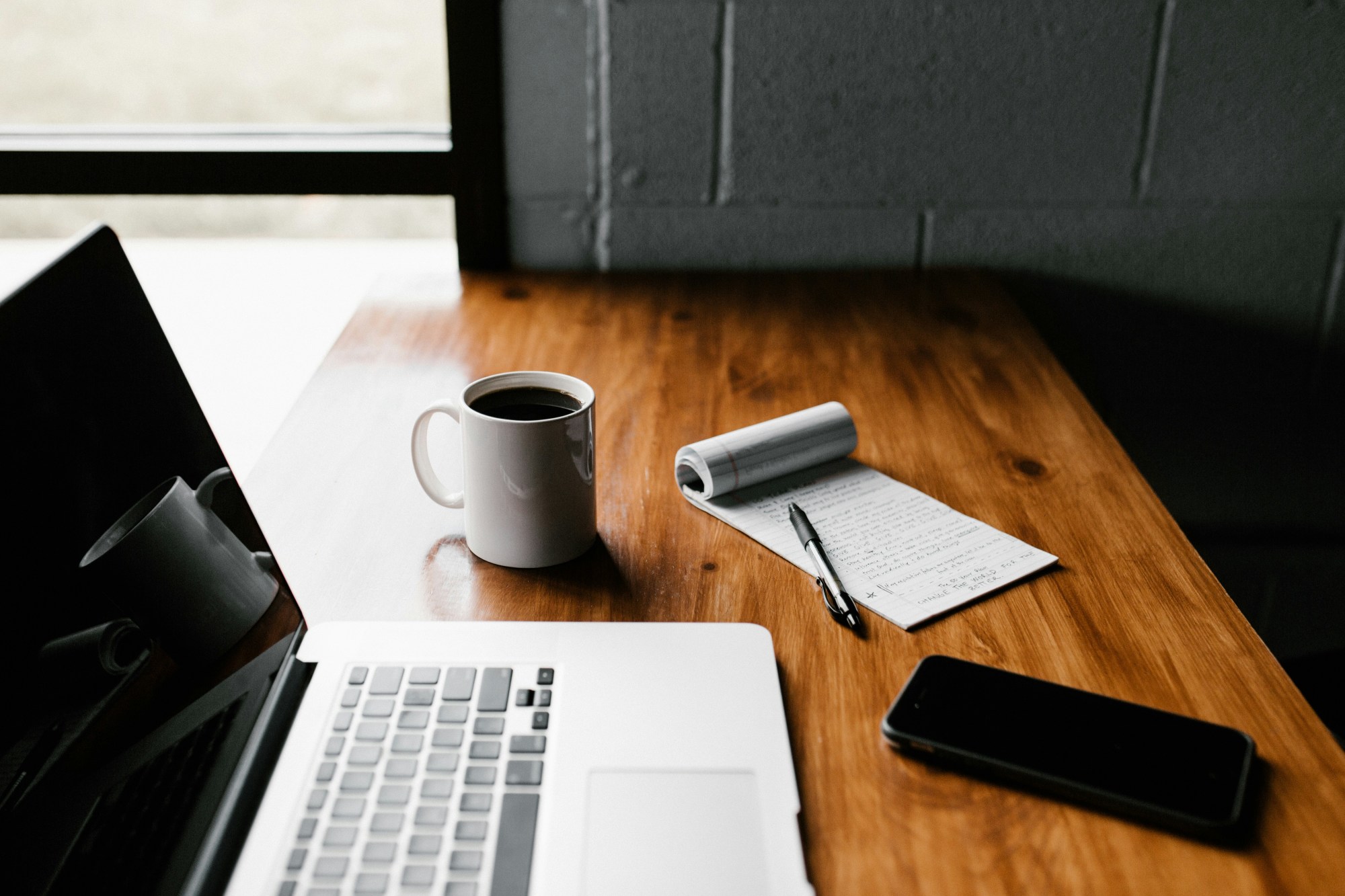 Un ordinateur portable posé sur un bureau à côté d'une tasse de café
