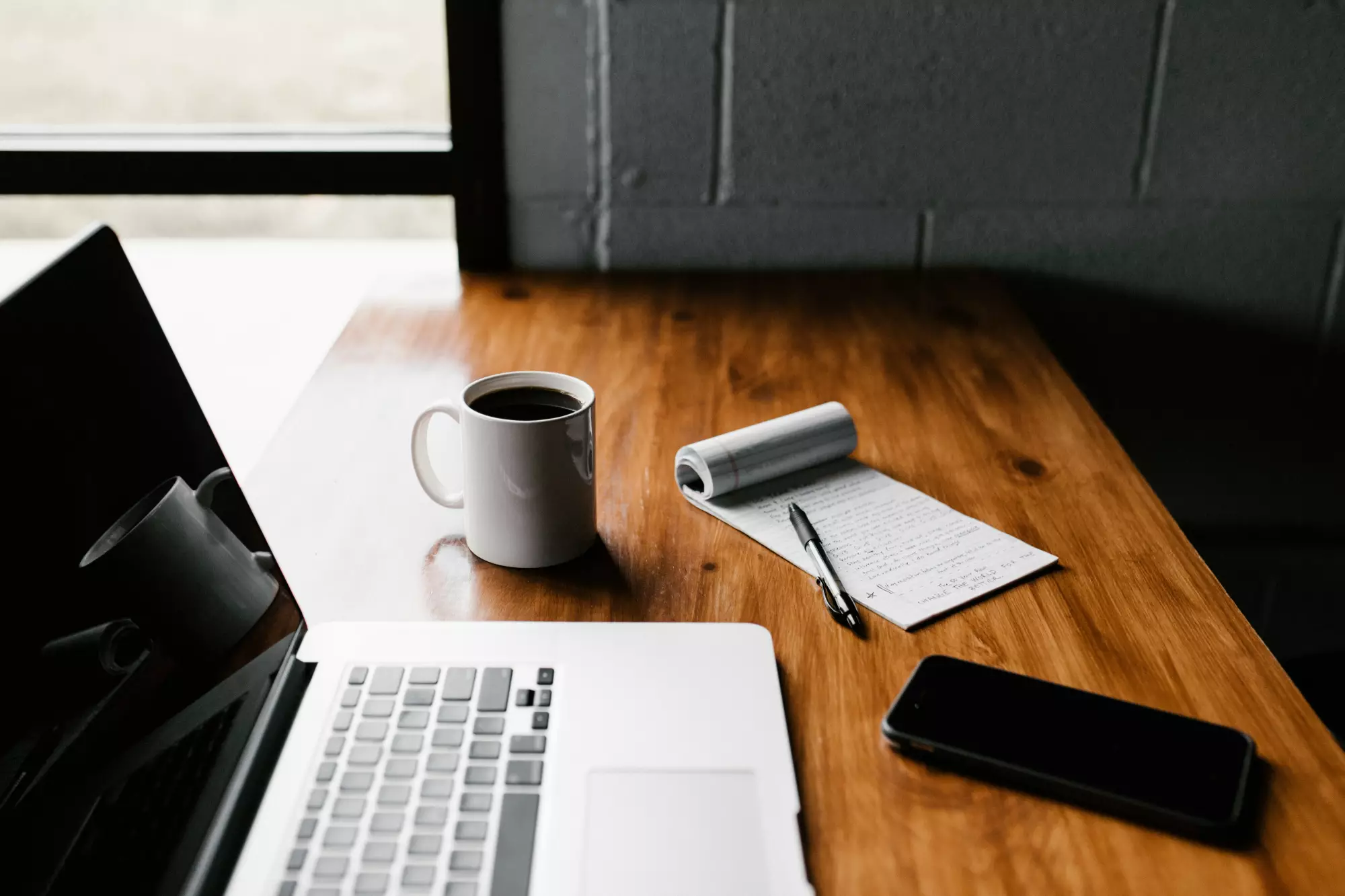 Un ordinateur portable posé sur un bureau à côté d'une tasse de café