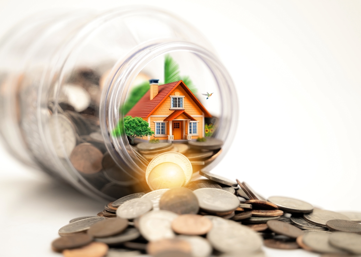 Diverses options existent pour investir à Nîmes investir à Nîmes – Une maison dans un bocal couché rempli de pièces de monnaie qui se déversent